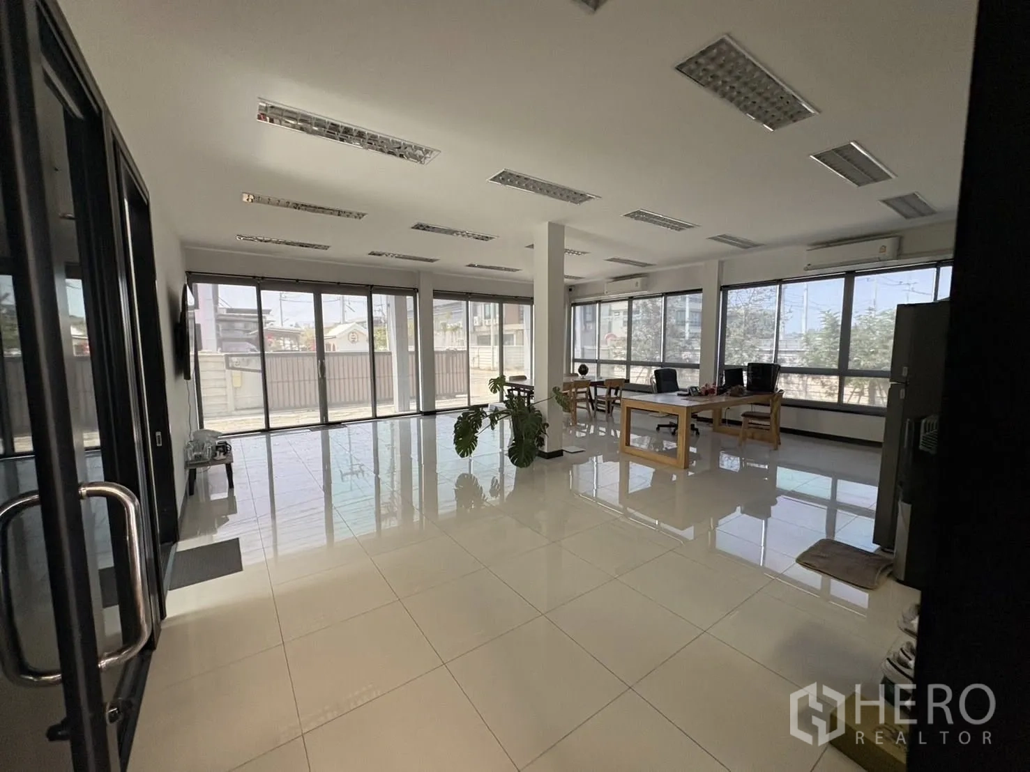 โรงงาน for rent or sale in Bang Len, Nakhon Pathom - พื้นที่ออฟฟิศสว่างด้วยหน้าต่างกระจก พื้นกระเบื้องเงา และโต๊ะทำงาน