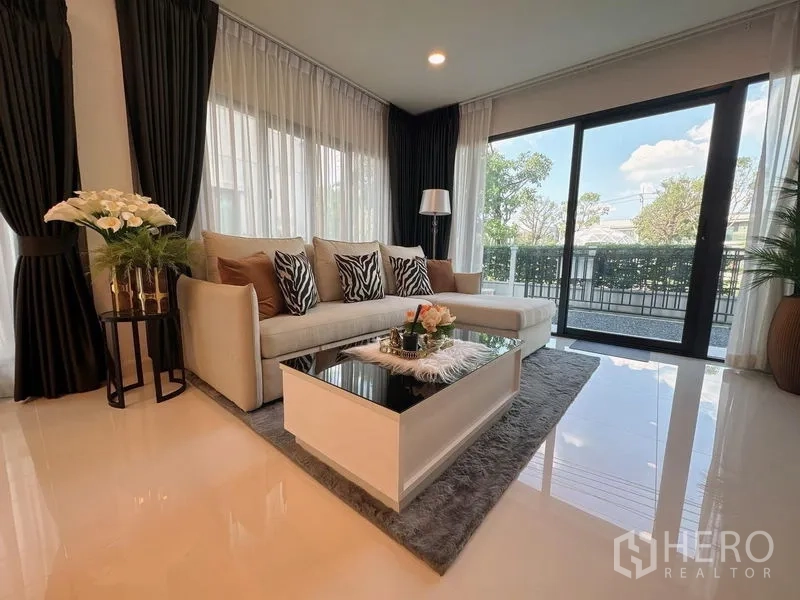 Detached House for rent or sale in Bang Phli, Samut Prakan - Another view of the bright living room with sectional sofa and glass doors.