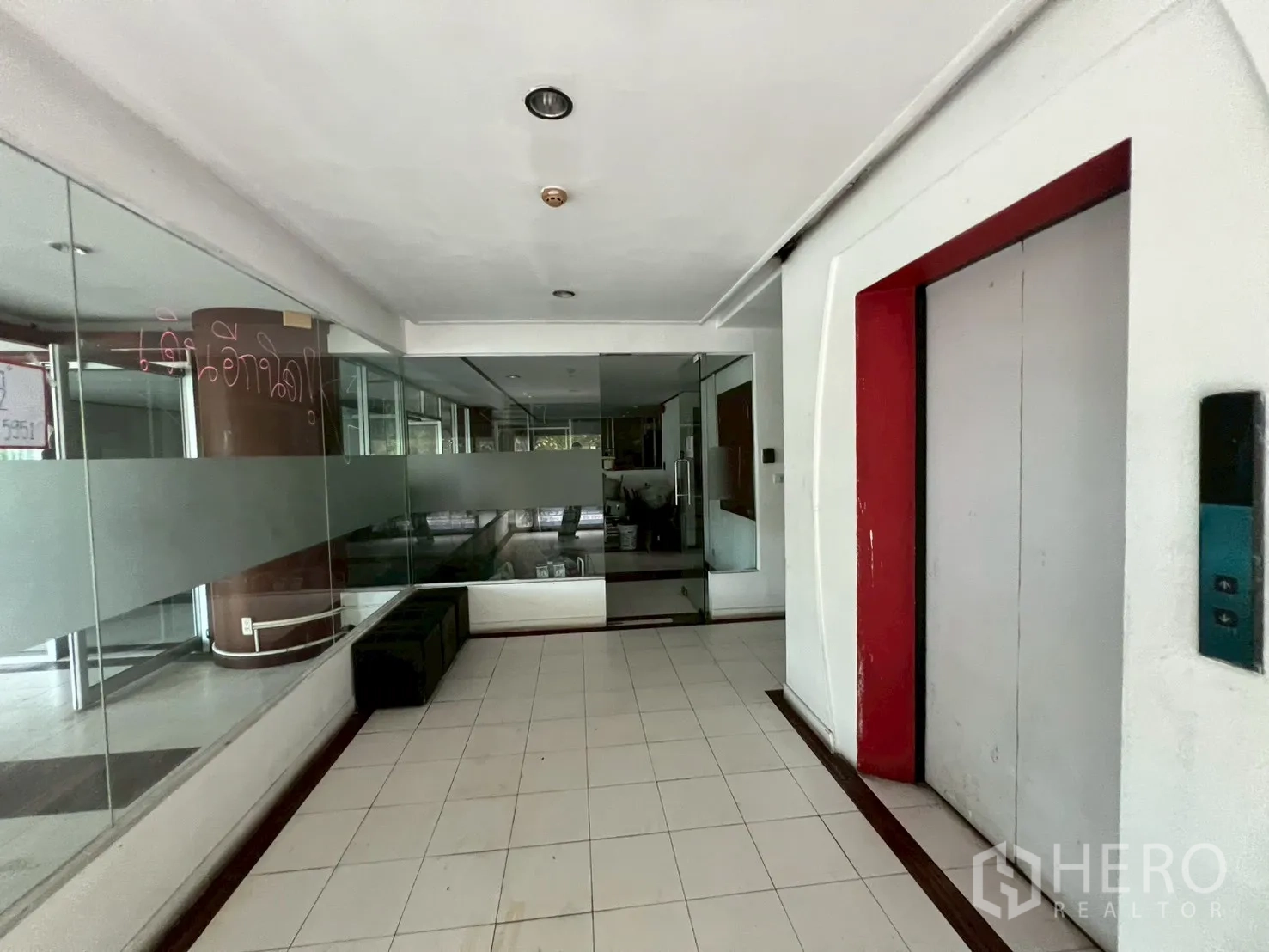 Retail Space for rent - Building elevator lobby with tiled flooring and glass wall access to the retail unit.