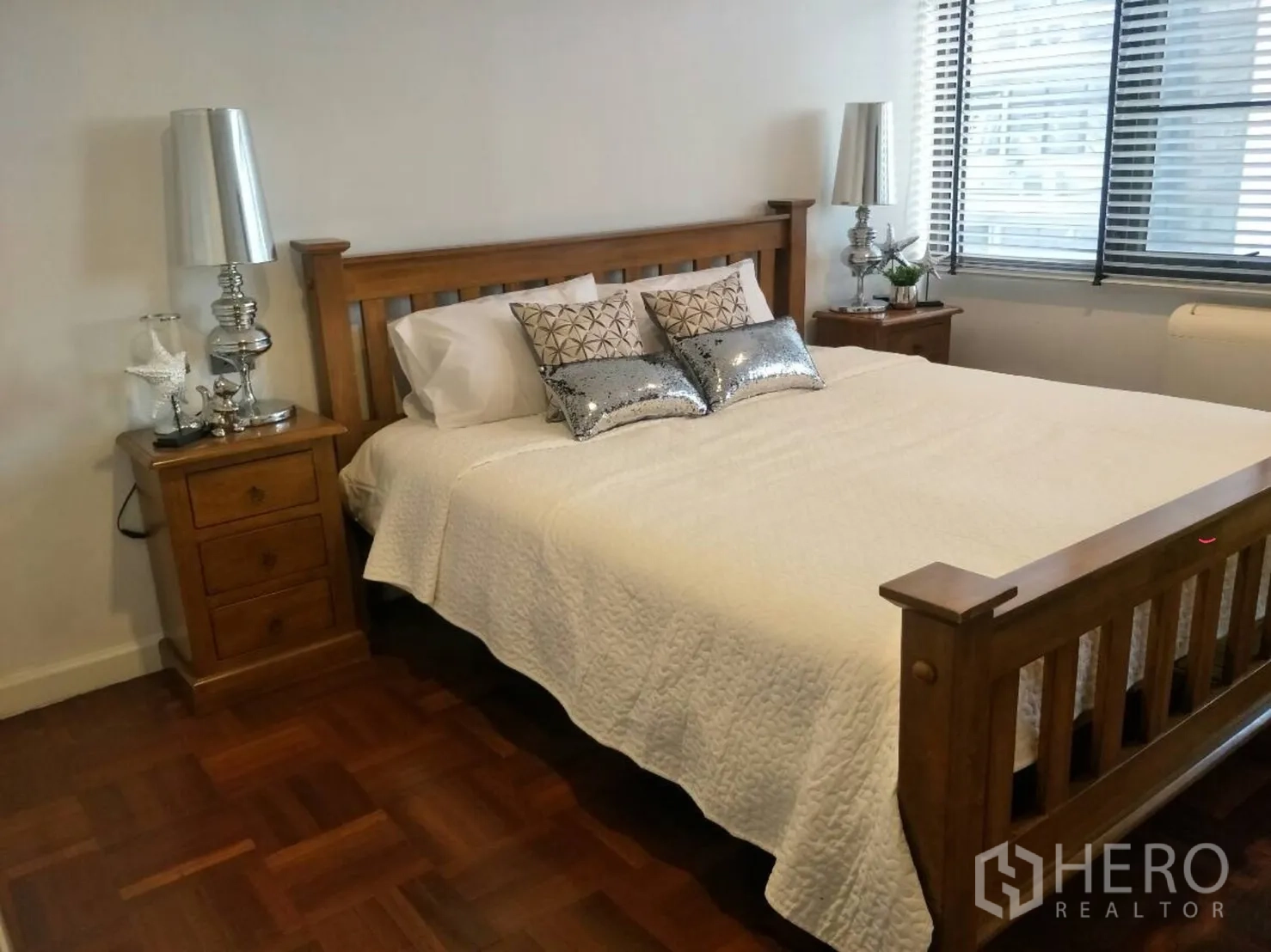 คอนโด ให้เช่าในWatthana, Bangkok - ห้องนอนคิงไซส์ โต๊ะข้างเตียงไม้ โคมไฟสีเงิน และมู่ลี่หน้าต่าง