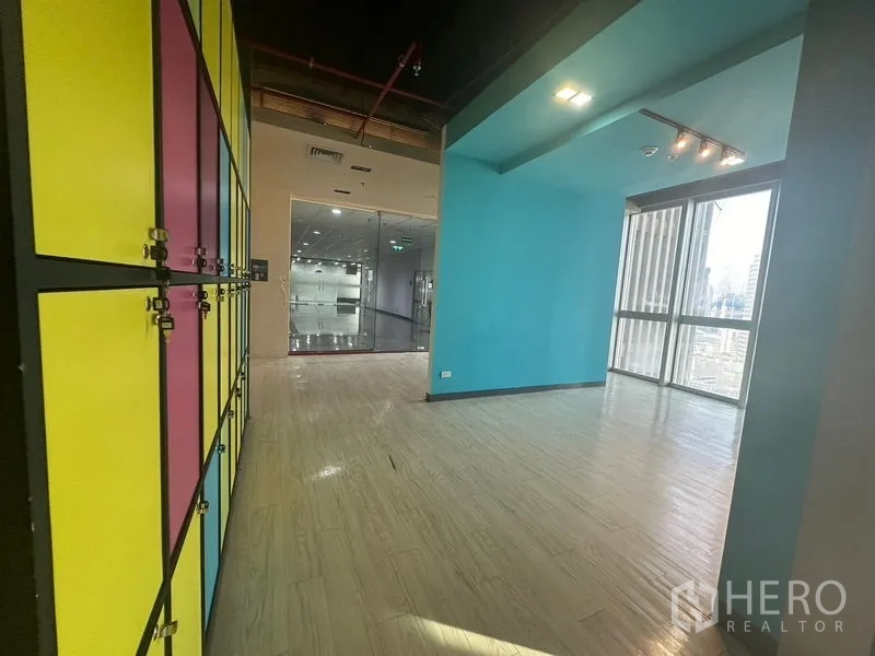 Office Space for rent in Bang Rak, Bangkok - Entrance zone with multicolor staff lockers and a blue breakout nook beside glazing.