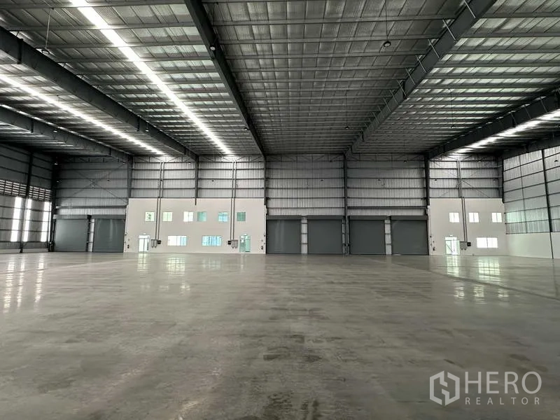 工厂 出租在Bang Sao Thong, Samut Prakan - 宽敞仓库内部，抛光地面，约8米净高，钢结构采光屋顶