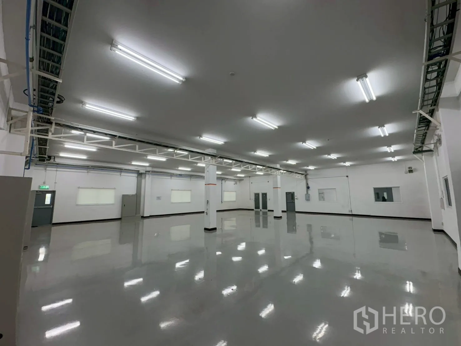 Factory for sale in Bang Bo, Samut Prakan - Columned work space with cable trays and reflective epoxy floor.