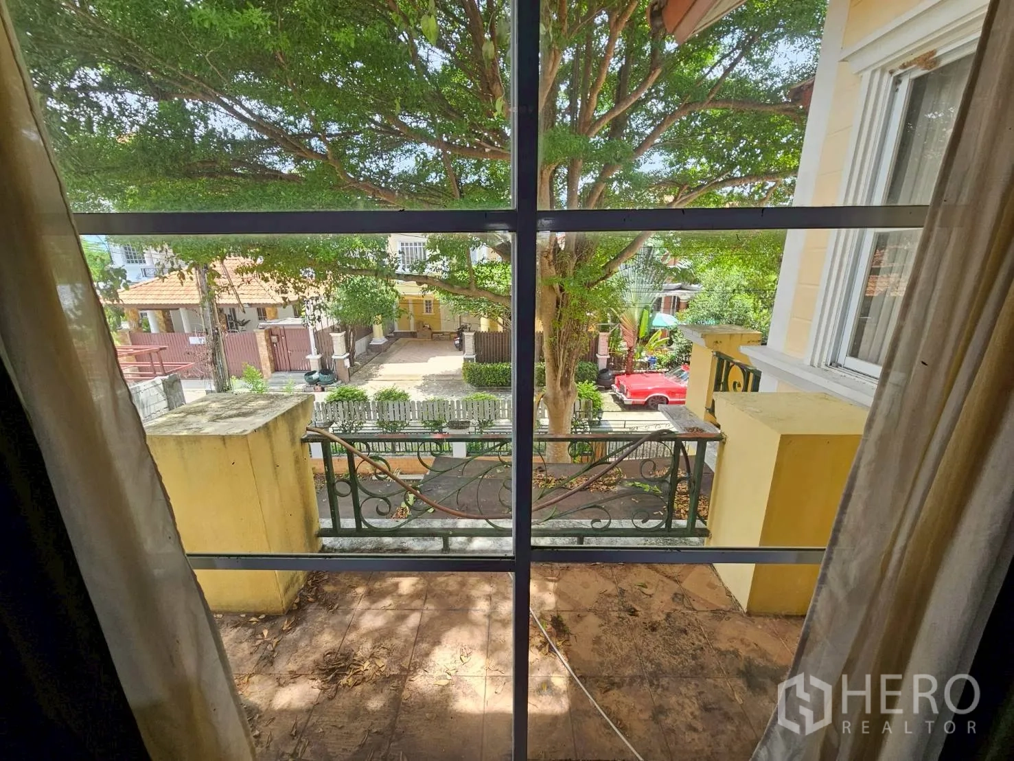 Detached House for rent or sale in Bang Lamung, Chon Buri - View from upstairs balcony window over a tree-lined street and front gate.