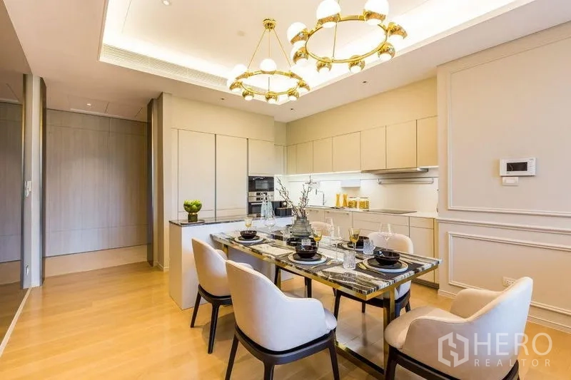 คอนโด ให้เช่าในPathum Wan, Bangkok - พื้นที่รับประทานอาหารโต๊ะหินอ่อน ใต้โคมไฟทอง คู่กับครัวสีขาวทันสมัย