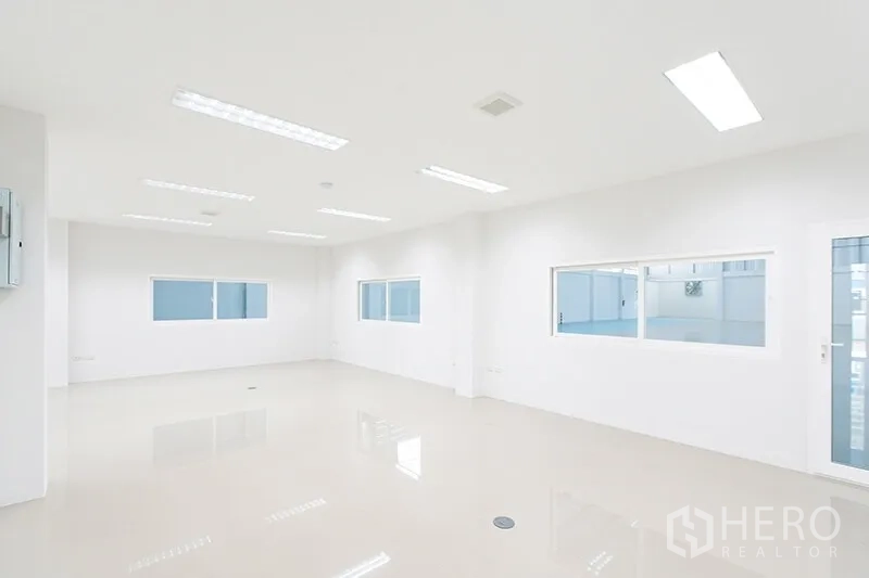 Warehouse for rent in Bang Bo, Samut Prakan - Bright office room with windows overlooking the warehouse floor and LED lighting.