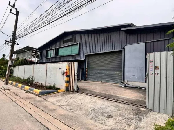 คลังสินค้า ให้เช่าในPrawet, Bangkok - มุมมองด้านหน้าโกดังโครงเหล็กพร้อมประตูม้วนและรั้วหน้าทางเข้า