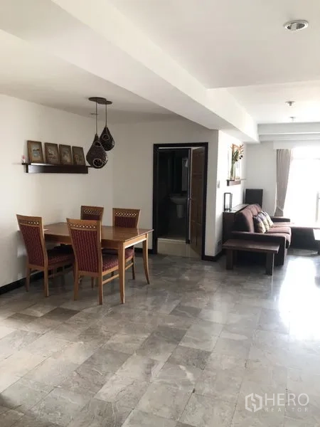 Condominium for rent in Watthana, Bangkok - Bright dining area with a four-seat wooden table, pendant lights, and tiled floors.