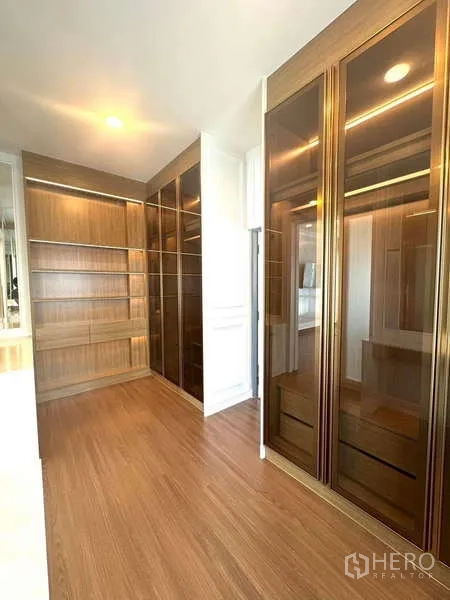 Detached House for rent in Bang Phli, Samut Prakan - Custom walk‑in closet with glass‑front cabinets and wood shelving