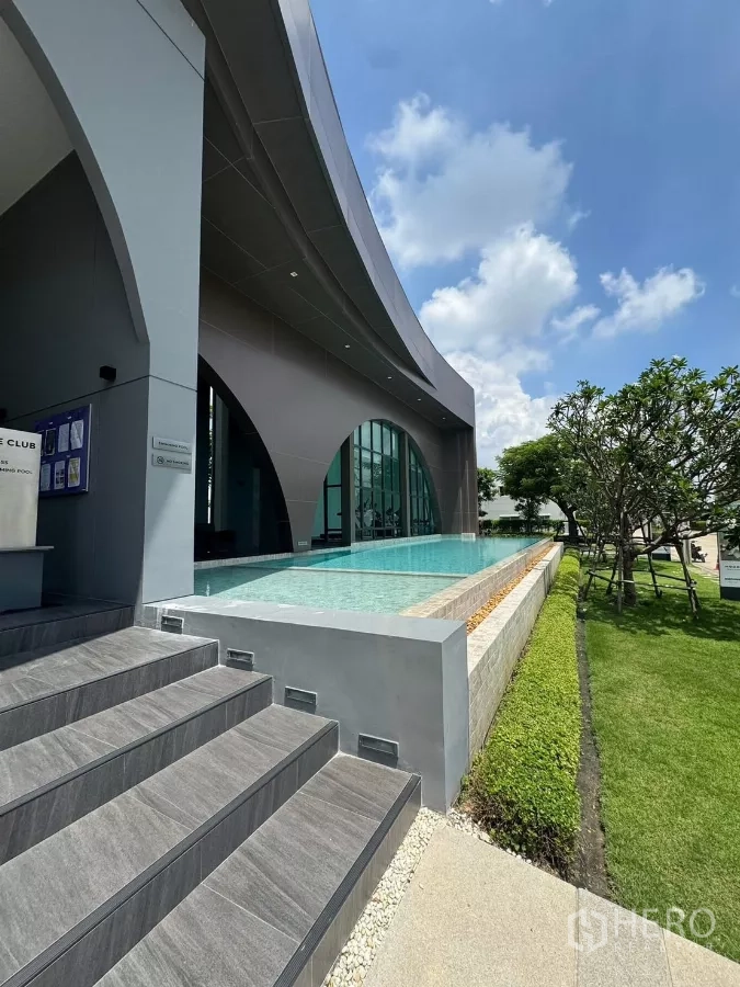 Detached House for rent or sale in Bang Bo, Samut Prakan - Clubhouse exterior with elevated lap pool, steps, and landscaped lawn.