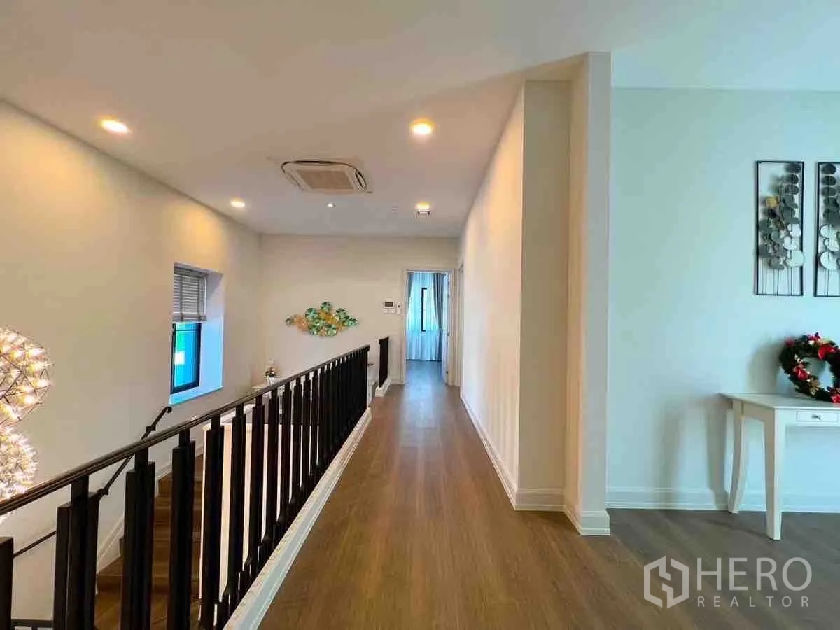 Detached House for rent or sale in Saphan Sung, Bangkok - Upstairs hallway with black balustrade leading to bedrooms