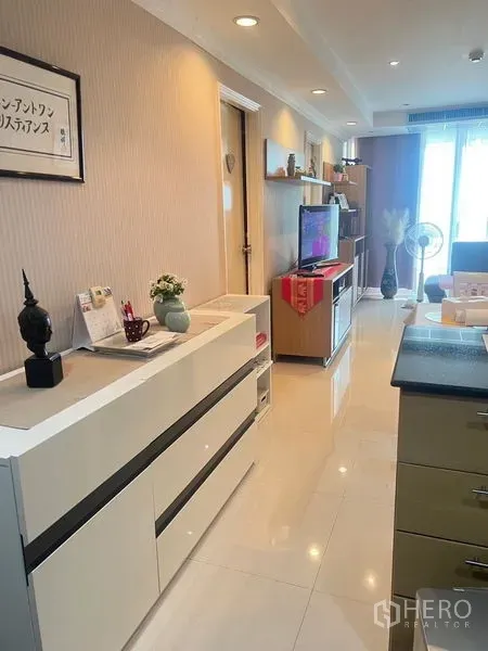 公寓 出售在Watthana, Bangkok - 走廊式起居区明亮，电视柜与展示架，亮面瓷砖地面，位于瓦他那公寓。