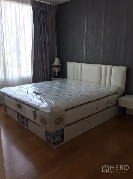 คอนโด ให้เช่าในWatthana, Bangkok - ห้องนอนพร้อมเตียงควีน เฮดบอร์ดบุหนังสีขาว ผนังลายเทา และหน้าต่างบานใหญ่พร้อมผ้าม่าน