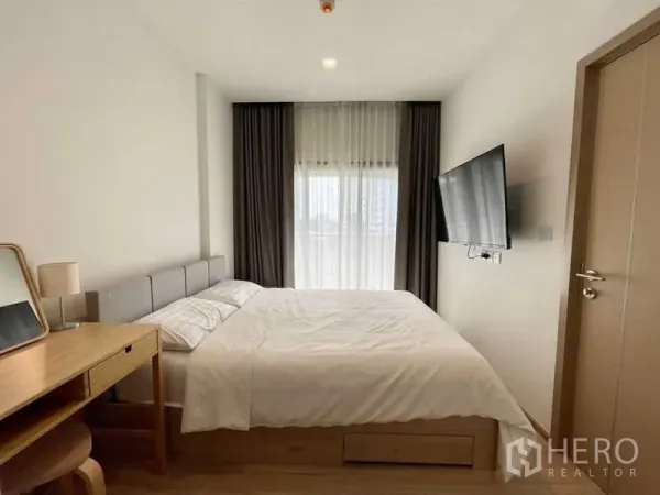 คอนโด ให้เช่าหรือขายในWatthana, Bangkok - ห้องนอนมินิมอล ผ้าม่านโปร่ง ทีวีติดผนัง และแสงธรรมชาติอ่อนๆ