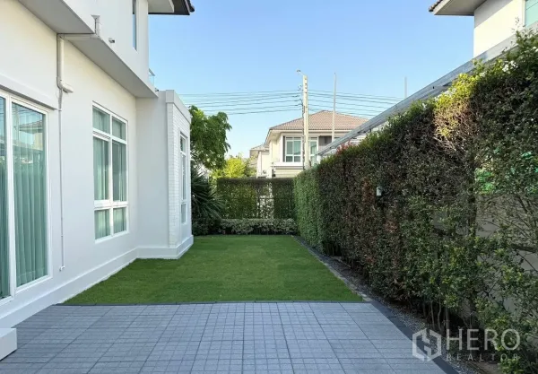 Detached House for rent in Prawet, Bangkok - Paved patio and grass yard along the side of the detached home