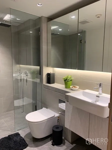 公寓 出租在Bang Rak, Bangkok - 带背光镜柜的洗手台与步入式淋浴。