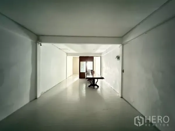 อาคารพาณิชย์ ให้เช่า - ห้องสีขาวสว่าง มีโต๊ะและประตูบานกระจกด้านหน้า