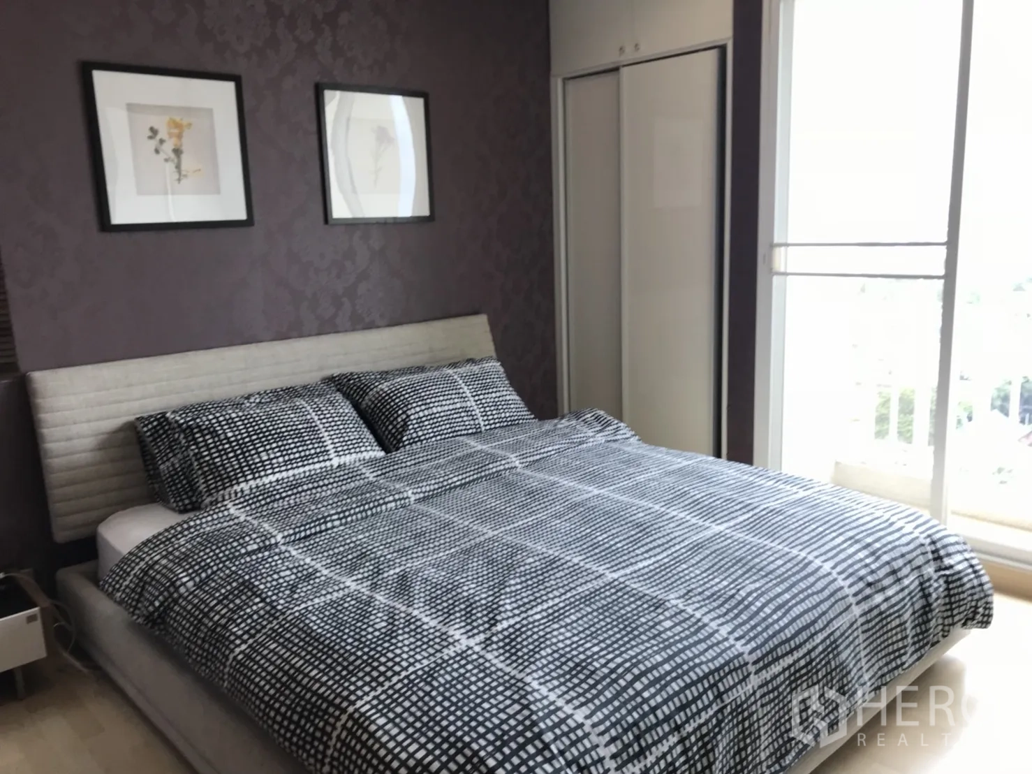 Condominium for rent in Watthana, Bangkok - Master bedroom with large bed, sliding wardrobe, and balcony access bringing in natural light.