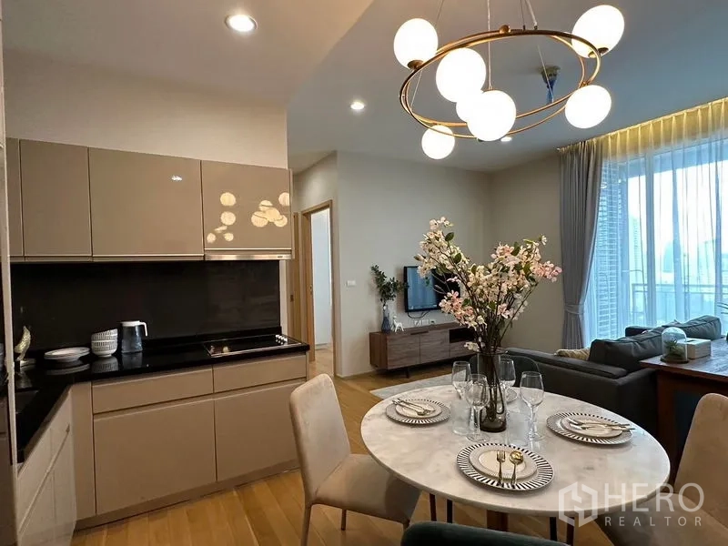 คอนโด ให้เช่าในWatthana, Bangkok - ครัวดีไซน์โมเดิร์นตู้สีเบจ พร้อมโต๊ะทานข้าวทรงกลมมองเห็นพื้นที่นั่งเล่น