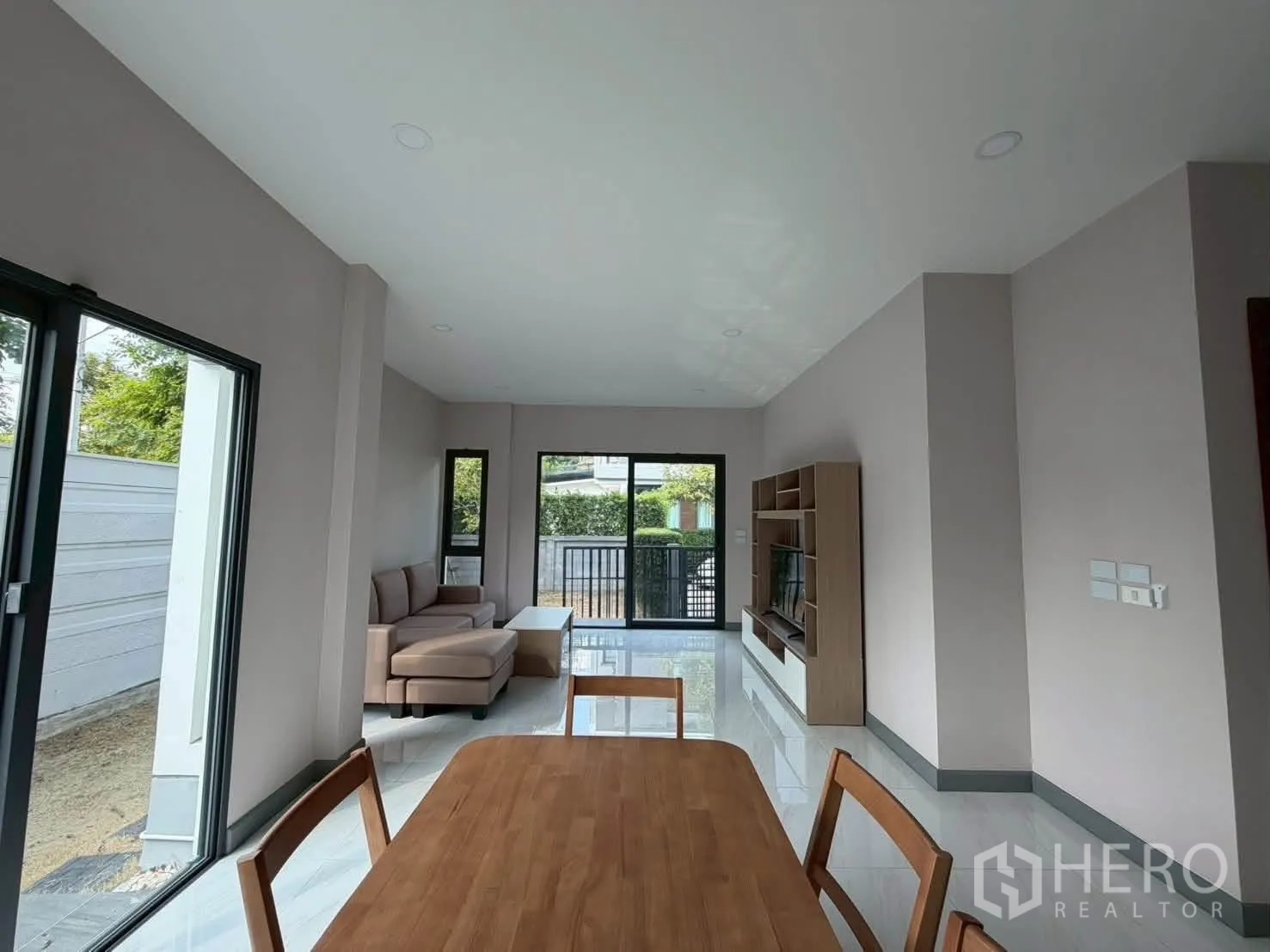 บ้านเดี่ยว for rent or sale in Prawet, Bangkok - โถงนั่งเล่นและทานข้าวแบบเปิดโล่ง มีโซฟา ชุดโต๊ะทานอาหาร ชั้นวางทีวี และประตูกระจกบานเลื่อน