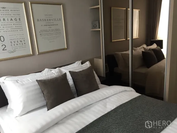 公寓 出售在Bang Rak, Bangkok - 温馨卧室，配软包床、镜面衣柜与装饰画