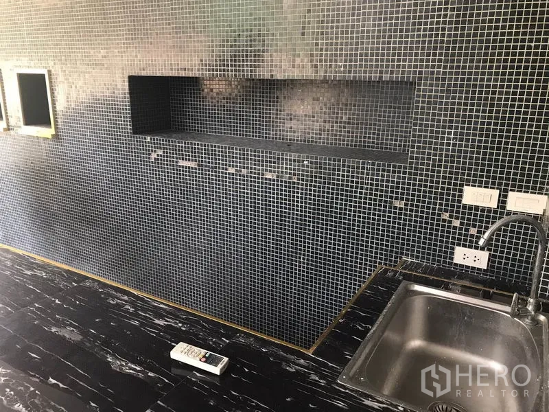 零售空间 出租在Watthana, Bangkok - 马赛克墙面、内凹置物台、电源插座与不锈钢水槽。