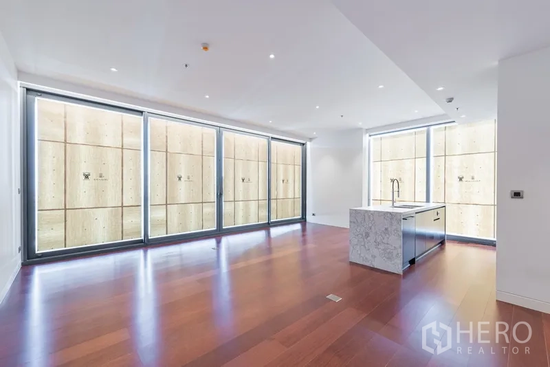 คอนโด ขายในWatthana, Bangkok - ห้องนั่งเล่น-รับประทานอาหารขนาดใหญ่ ผนังกระจกบานเลื่อนยาวและไอส์แลนด์หินอ่อนกลางห้อง