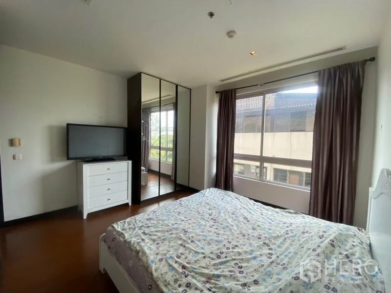 Condominium for rent in Yan Nawa, Bangkok - Bedroom with two wide windows, curtains and natural light.