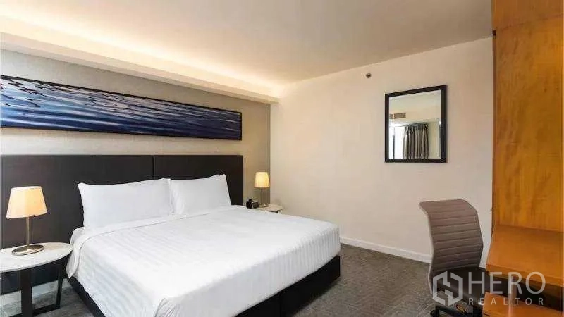 Condominium for rent in Bang Kho Laem, Bangkok - Bright master bedroom with a king-size bed, bedside lamps and modern wall art.