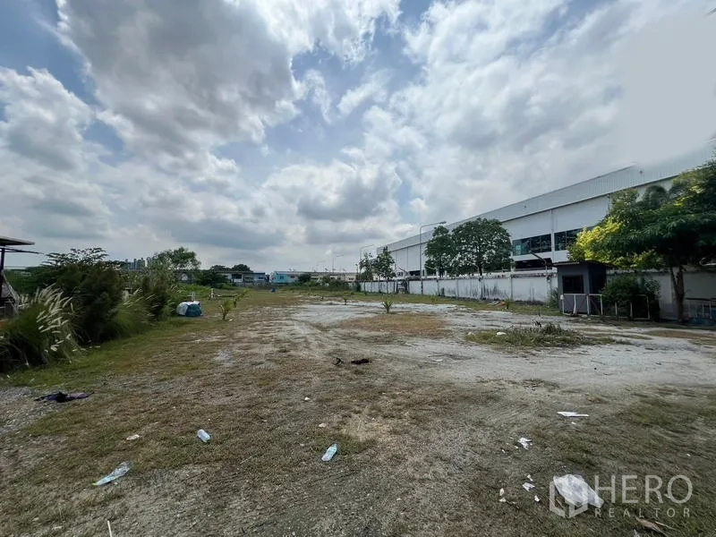 โชว์รูม ให้เช่าในMueang Samut Prakan, Samut Prakan - ลานโล่งด้านหลัง ปูดินและหญ้า ข้างอาคารอุตสาหกรรม