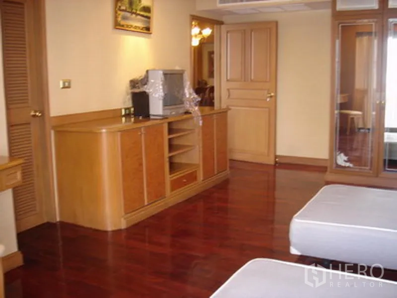 อพาร์ทเมนท์ ให้เช่าในKhlong Toei, Bangkok - มุมห้องนอนพร้อมตู้วางทีวีบิวท์อิน พื้นไม้เงางาม และประตูไม้