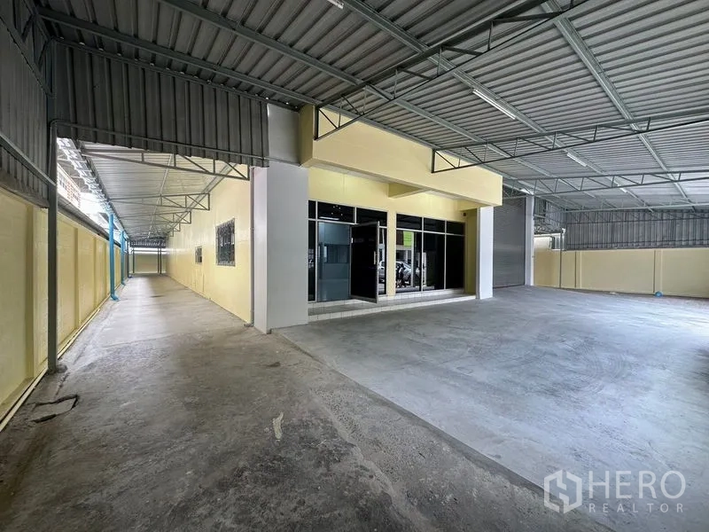 工厂 出租在Pathum Thani - 有顶入口，玻璃门办公室紧邻装卸区。