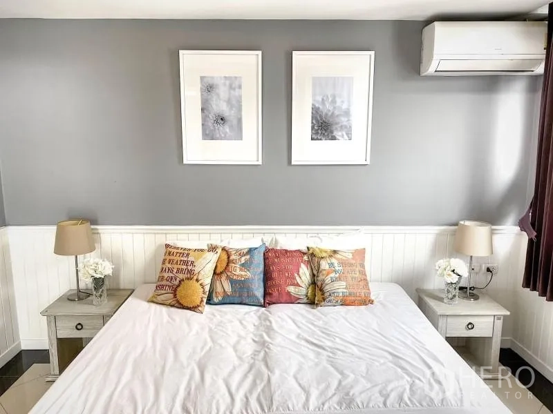 คอนโด ให้เช่าในKhlong Toei, Bangkok - ห้องนอนผนังเทา เตียงใหญ่ หมอนลายสีสัน โคมไฟหัวเตียง และเครื่องปรับอากาศ