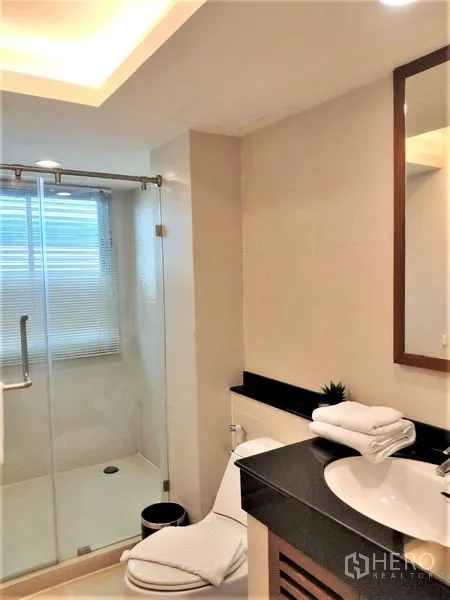 公寓 出租在Bang Rak, Bangkok - 现代浴室，玻璃淋浴间、洗手台与坐便。