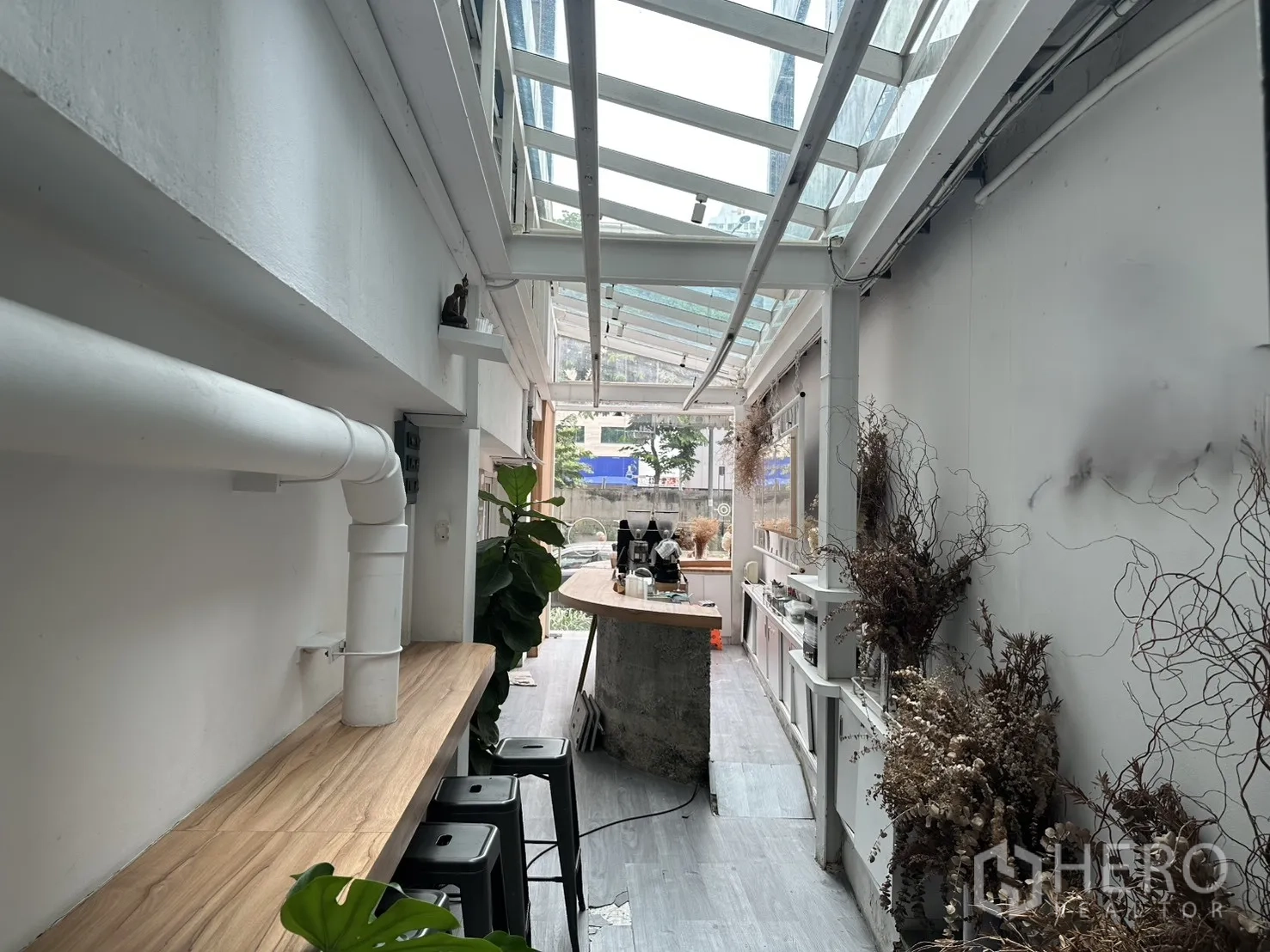 零售空间 for rent in Bang Rak, Bangkok - 玻璃顶走廊设木质吧台与高脚凳，墙边点缀绿植。