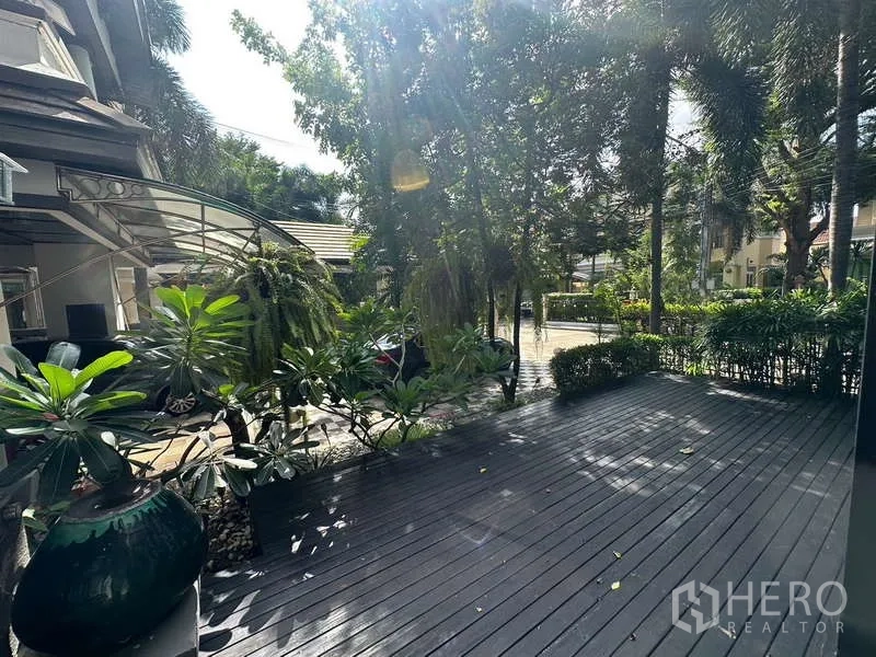 Detached House for sale in Suan Luang, Bangkok - Sunlit terrace deck with planters and tropical foliage at the front yard.
