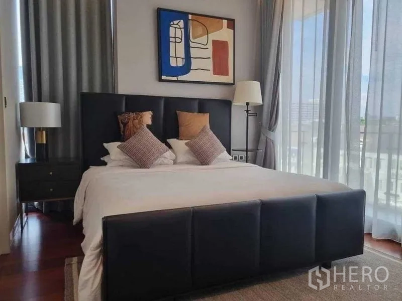 公寓 出租在Watthana, Bangkok - 主卧，软包床、抽象画与落地窗帘。