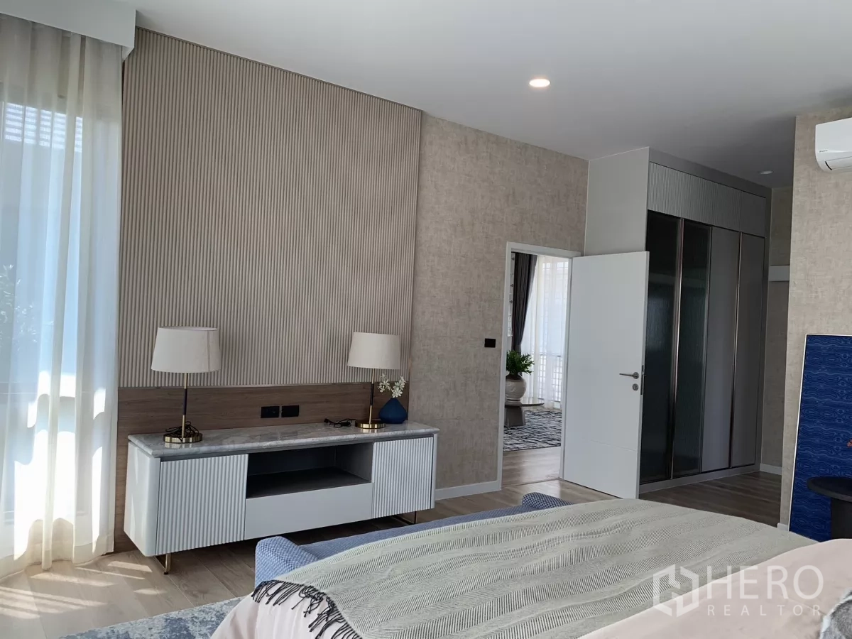 Detached House for rent in Bang Kapi, Bangkok - Master suite media console and walk‑in wardrobe access with natural light.