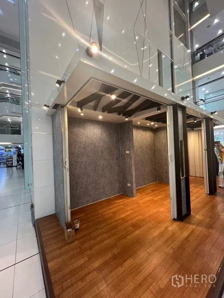 零售空间 出租 - 现代商场中带木地板、灰色墙面与射灯的小型零售展位