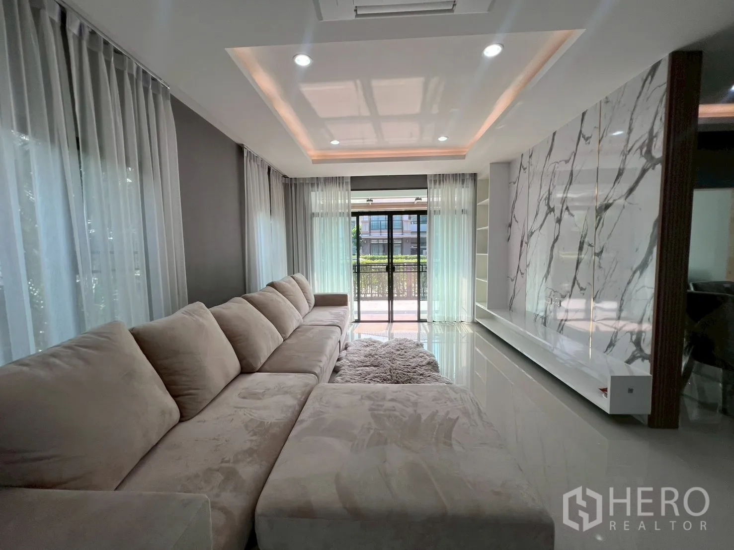 Detached House for rent or sale in Bang Phli, Samut Prakan - Long living space facing marble feature wall and sliding doors to garden.