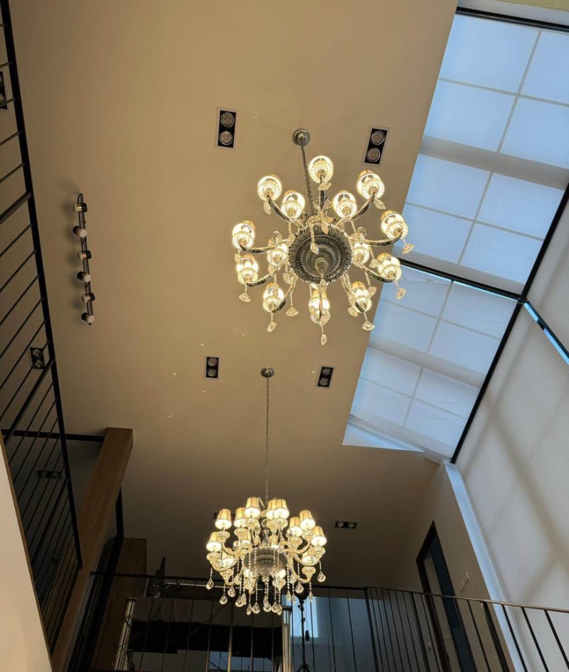 บ้าน ขายในKhlong San, Bangkok - โคมระย้าคริสตัลสองดวงแขวนบนเพดานสูงขนาดใหญ่ ข้างสกายไลต์และราวเหล็ก