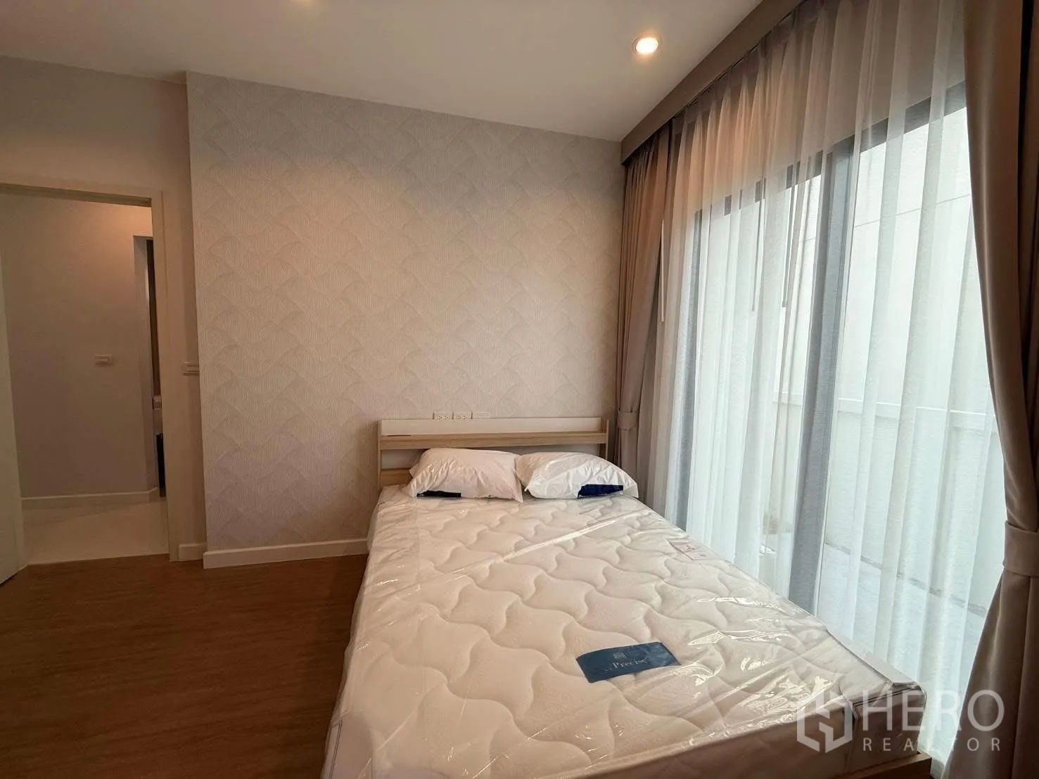 Detached House for rent in Bang Phli, Samut Prakan - Cozy bedroom with double bed, textured wallpaper, and floor-to-ceiling sheer curtains.