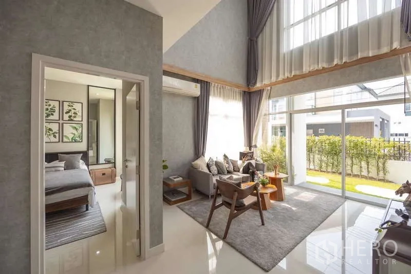 บ้าน ขายในLam Luk Ka, Pathum Thani - ห้องนั่งเล่นโปร่งเพดานสูงสองชั้น กระจกเต็มบาน เชื่อมต่อห้องนอนสวีท