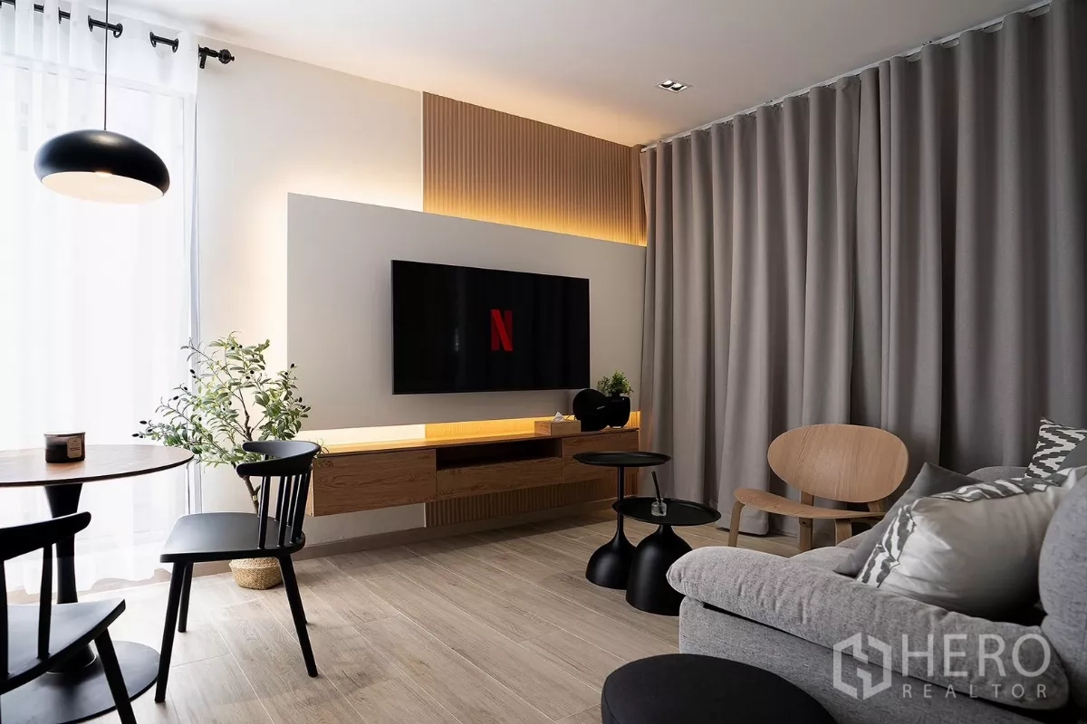 บ้าน ให้เช่าในHuai Khwang, Bangkok - ห้องนั่งเล่นสไตล์โมเดิร์น ทีวีติดผนัง โซฟาสีเทา และมุมทานอาหาร