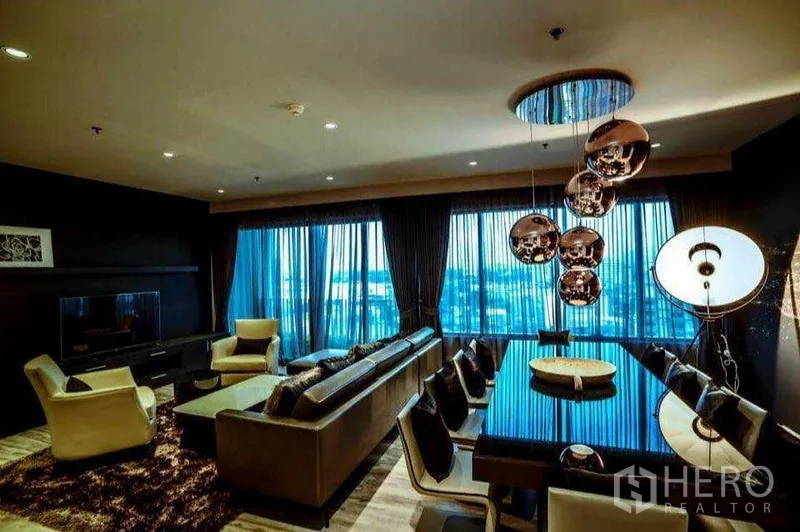 คอนโด ให้เช่าหรือขายในKhlong Toei, Bangkok - ห้องนั่งเล่นและรับประทานอาหารพร้อมโซฟาตัวยาว ชุดวางทีวี และโคมไฟแขวนดีไซน์