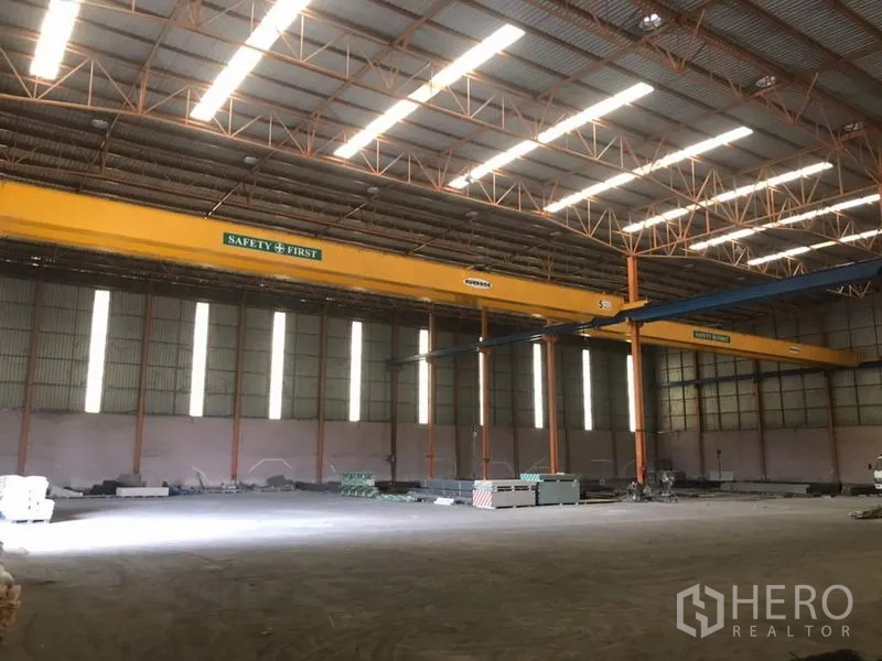 Home Office for sale in Khlong Luang, Pathum Thani - High-clear warehouse interior featuring overhead gantry cranes and skylight panels.