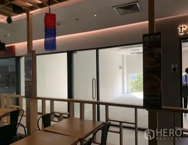 พื้นที่ขายปลีก ให้เช่าในBang Rak, Bangkok - หน้าร้านกระจกหันไปทางโซนรับประทานอาหารภายในอาคาร เห็นไฟเพดานและป้ายต่าง ๆ ชัดเจน