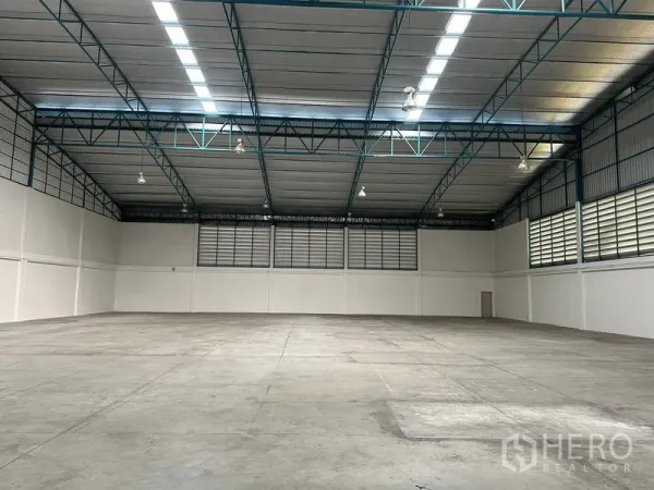工厂 出租在Si Racha, Chon Buri - 无柱大跨度仓库地面，高位照明与侧墙通风百叶。