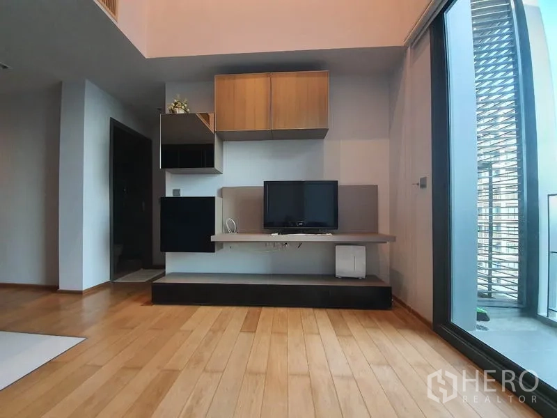 คอนโด ให้เช่าหรือขายในKhlong Toei, Bangkok - ชั้นวางทีวีและตู้ลอยในห้องนั่งเล่น เชื่อมต่อประตูออกระเบียง