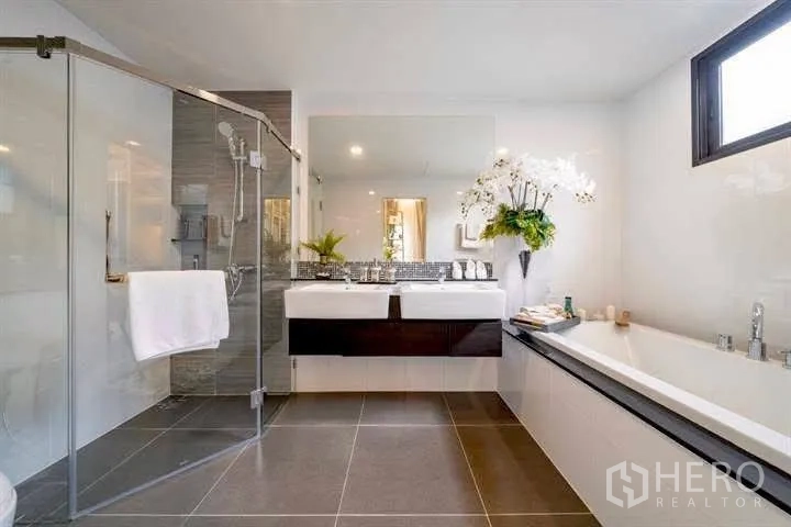 Detached House for rent or sale in Wang Thonglang, Bangkok - Spacious bathroom with glass shower, bathtub and double sinks.